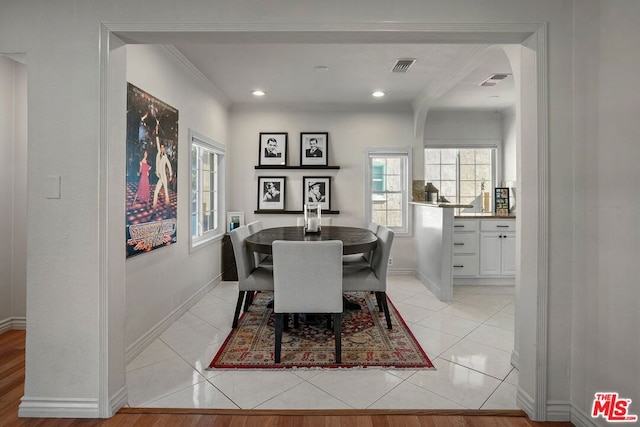 dining space featuring light tile patterned floors and ornamental molding