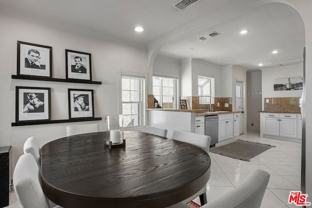 dining area featuring crown molding and light tile patterned floors