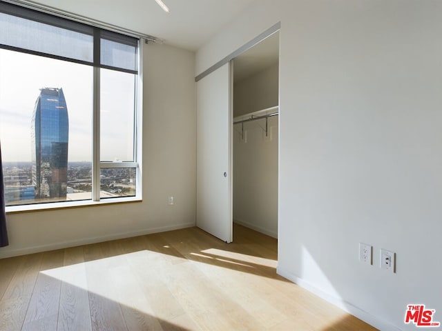 unfurnished bedroom with light hardwood / wood-style floors and a closet