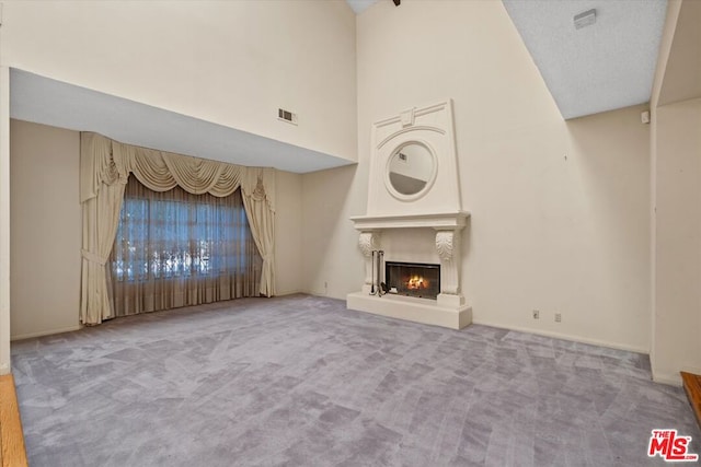 unfurnished living room featuring carpet floors and high vaulted ceiling