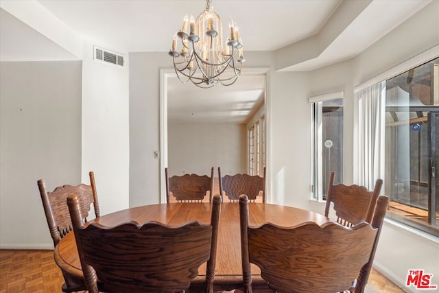 dining room with parquet floors and a chandelier