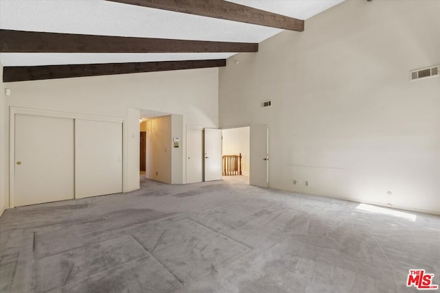 interior space featuring beamed ceiling, a closet, high vaulted ceiling, and carpet