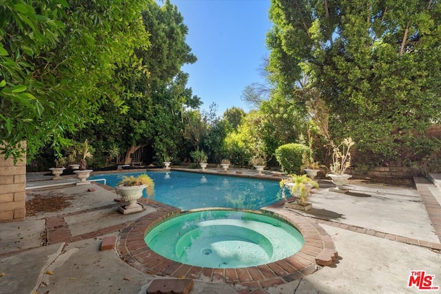 view of swimming pool featuring an in ground hot tub and a patio