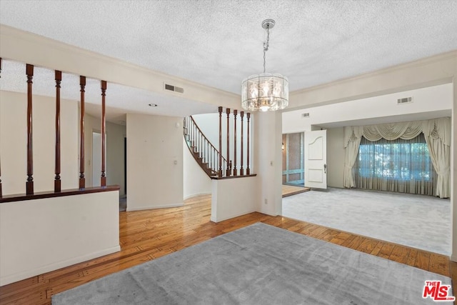 interior space with hardwood / wood-style flooring, a notable chandelier, and a textured ceiling