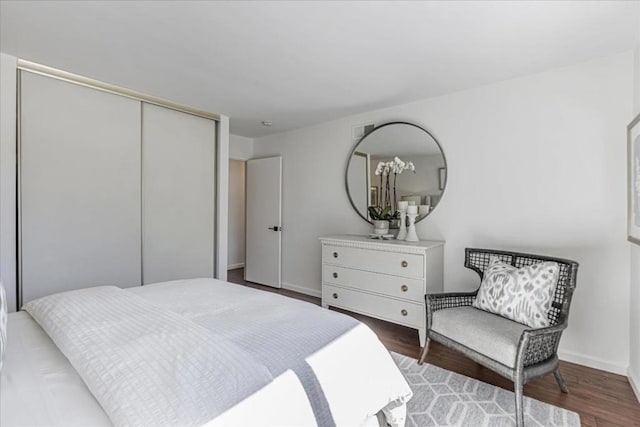 bedroom featuring dark wood-type flooring and a closet