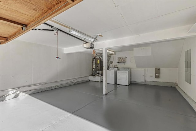 garage with washing machine and clothes dryer, a garage door opener, and gas water heater