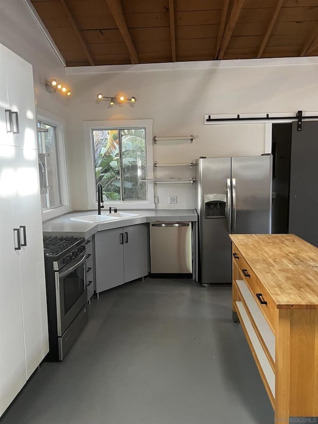 kitchen with stainless steel appliances, white cabinetry, sink, and wooden ceiling