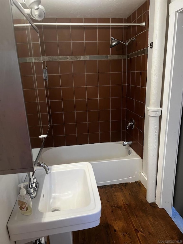 bathroom with tiled shower / bath, sink, and hardwood / wood-style floors