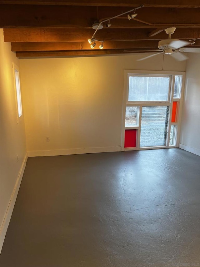 unfurnished room with ceiling fan and concrete flooring