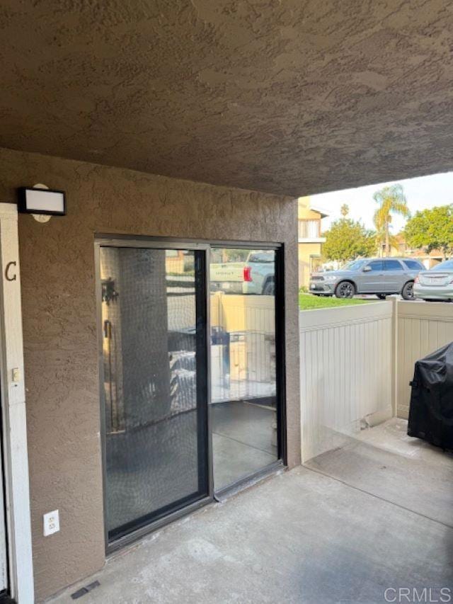 doorway to property featuring stucco siding