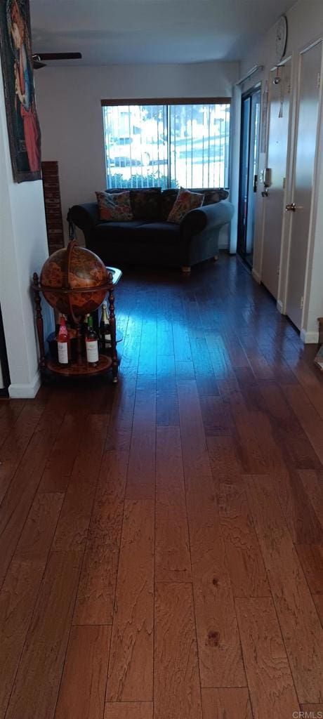 hallway with baseboards and dark wood-style floors