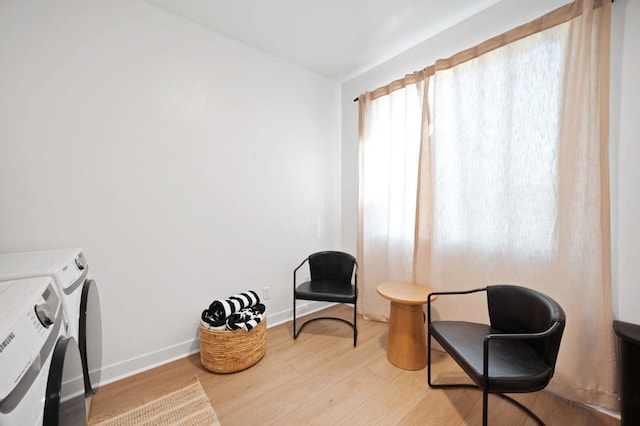 sitting room with separate washer and dryer and hardwood / wood-style floors