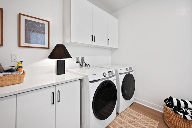 washroom with washer and clothes dryer, cabinets, and light wood-type flooring