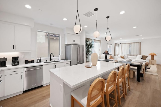 kitchen featuring sink, a center island, white cabinets, and appliances with stainless steel finishes