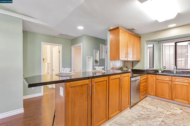 kitchen featuring sink, dishwasher, backsplash, kitchen peninsula, and dark stone counters