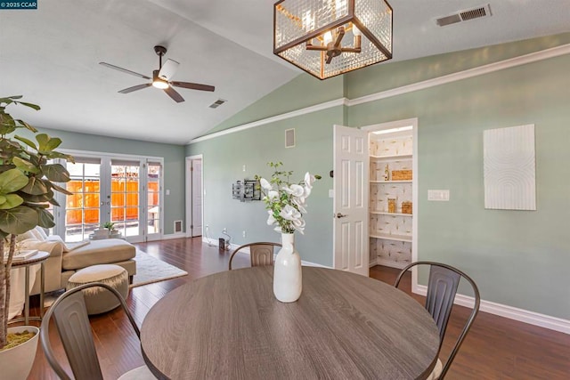 dining space with french doors, lofted ceiling, dark hardwood / wood-style flooring, and ceiling fan with notable chandelier