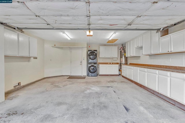 garage with stacked washing maching and dryer and gas water heater