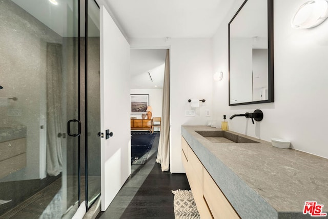 bathroom featuring vanity, an enclosed shower, and wood-type flooring