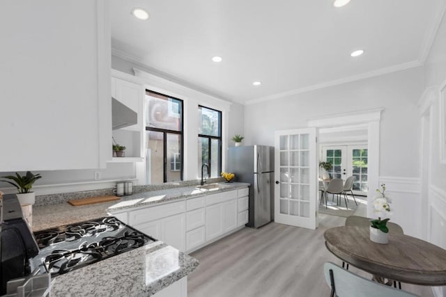 kitchen with white cabinetry, stovetop, stainless steel fridge, light stone counters, and french doors