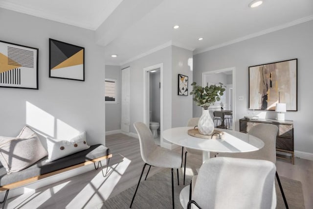 dining area featuring crown molding and light hardwood / wood-style flooring