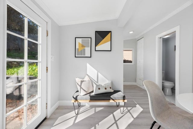 office space featuring vaulted ceiling, ornamental molding, and light hardwood / wood-style flooring