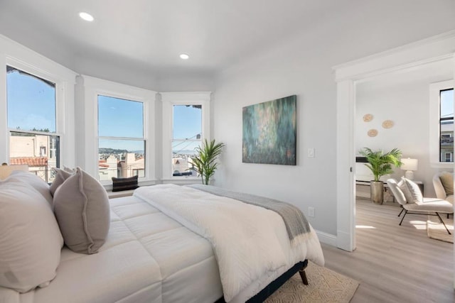 bedroom featuring multiple windows and light hardwood / wood-style floors