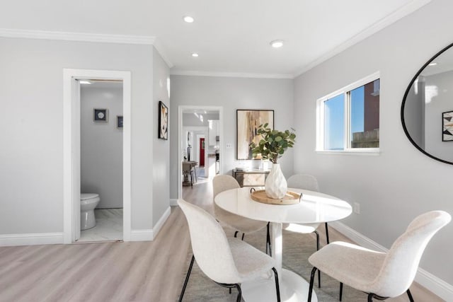 dining space with ornamental molding and light wood-type flooring