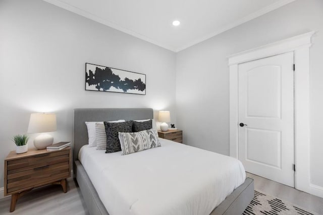 bedroom with ornamental molding and light hardwood / wood-style floors