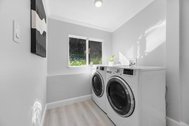 washroom with ornamental molding, separate washer and dryer, and light hardwood / wood-style flooring