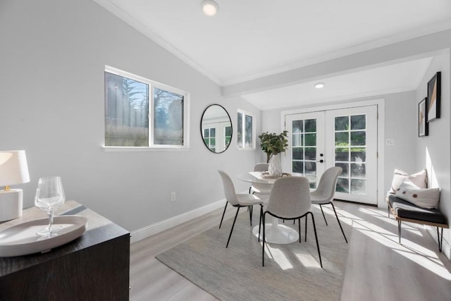 dining room featuring lofted ceiling, light hardwood / wood-style floors, and french doors