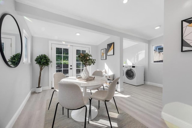 dining room featuring washer / clothes dryer, crown molding, light hardwood / wood-style flooring, and french doors