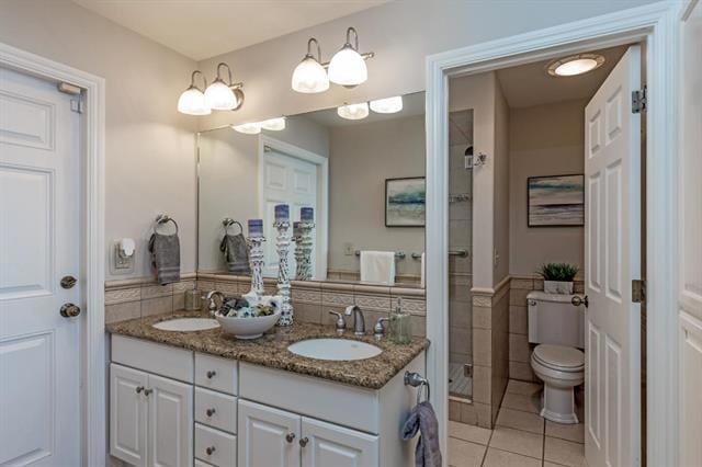 bathroom featuring tile walls, tile patterned flooring, vanity, a shower with shower door, and toilet