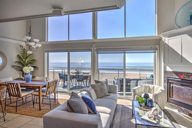 living room with a wealth of natural light, a chandelier, and a water view