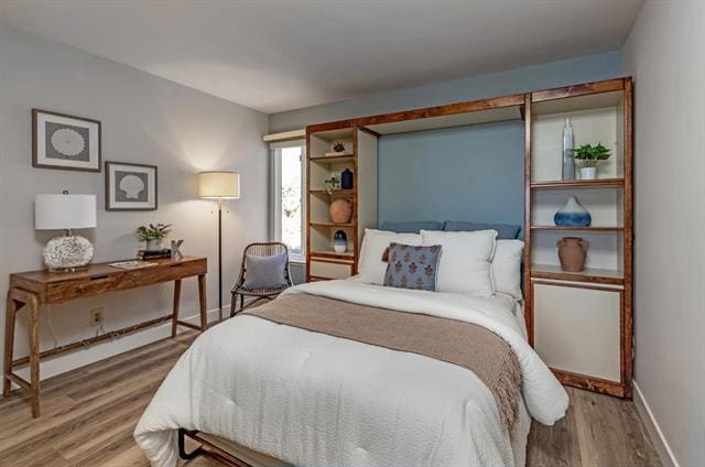 bedroom featuring hardwood / wood-style flooring and baseboard heating