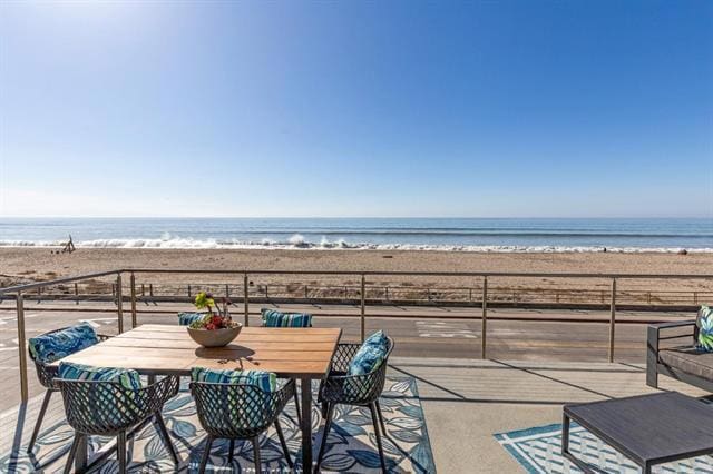 balcony with a water view and a beach view