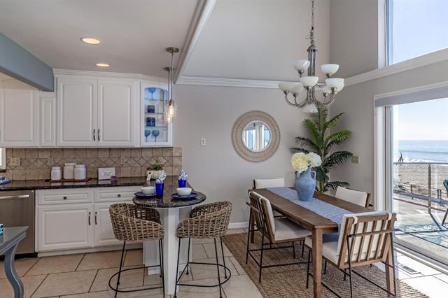 kitchen featuring a kitchen bar, dishwasher, pendant lighting, decorative backsplash, and white cabinets