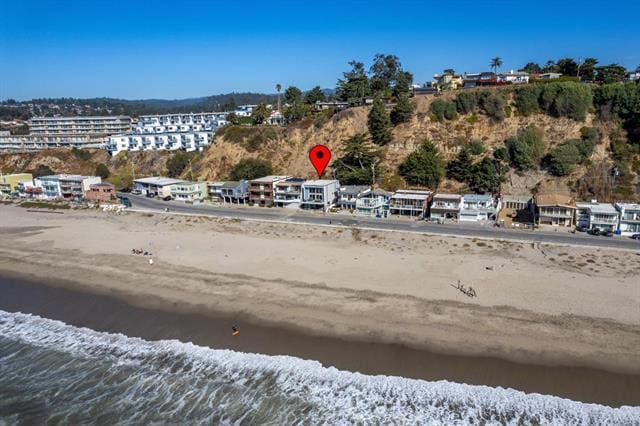 bird's eye view featuring a water view and a beach view