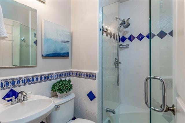 bathroom featuring sink, tile walls, and toilet