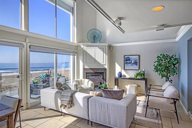 tiled living room with a water view, ornamental molding, a premium fireplace, and a wealth of natural light