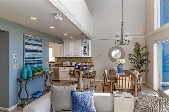 kitchen with white cabinetry, stainless steel dishwasher, a notable chandelier, pendant lighting, and backsplash