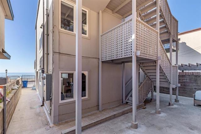 rear view of property featuring a patio and a water view