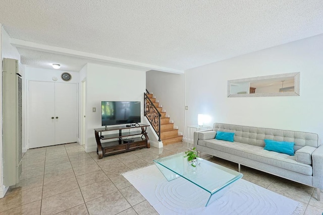 tiled living room featuring a textured ceiling