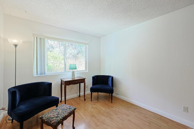 sitting room featuring light hardwood / wood-style flooring and a textured ceiling