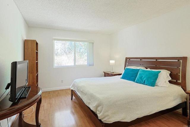 bedroom featuring a textured ceiling and light wood-type flooring