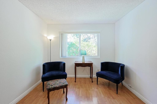 sitting room with light hardwood / wood-style flooring and a textured ceiling