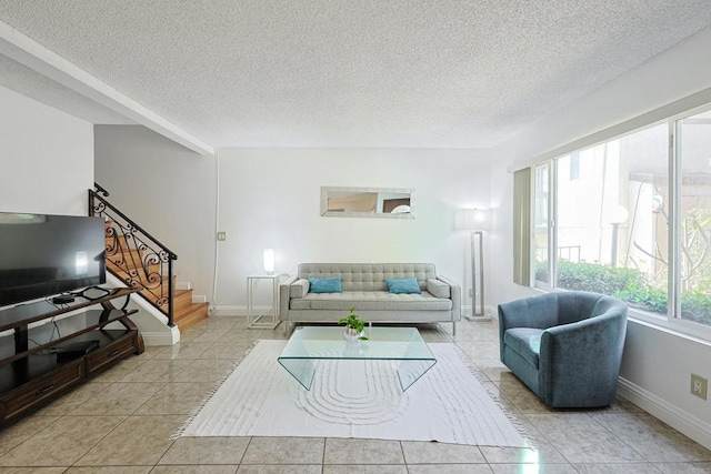 tiled living room featuring a textured ceiling