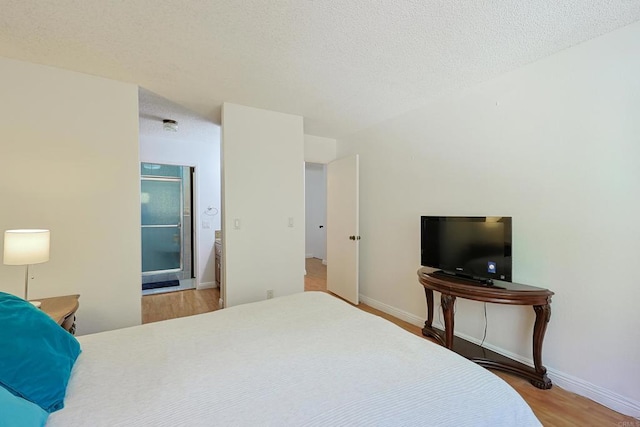 bedroom with wood-type flooring and a textured ceiling