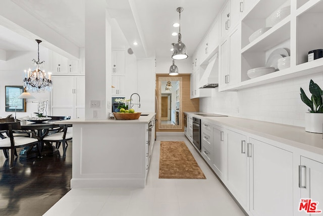 kitchen with sink, white cabinets, decorative light fixtures, custom exhaust hood, and stainless steel oven