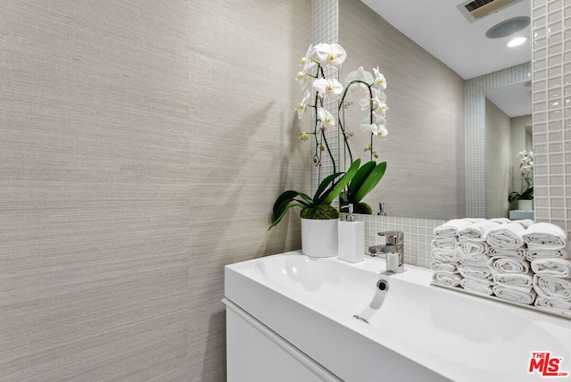 bathroom featuring vanity and tasteful backsplash