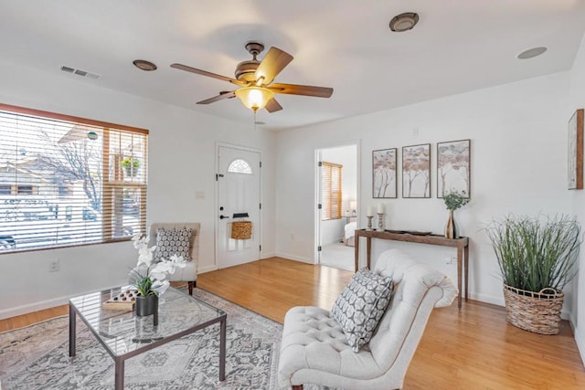 living room featuring ceiling fan and light hardwood / wood-style flooring